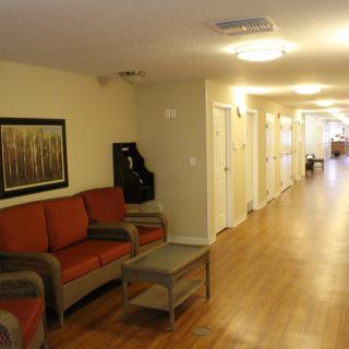 A hallway with a seating area, featuring sofas and a wooden floor.