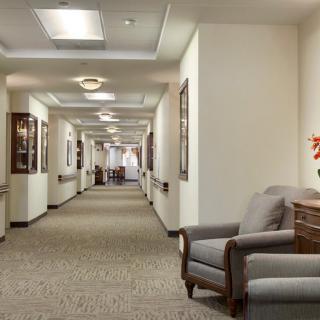 A well-lit hallway with comfortable seating and artwork adorning the walls.