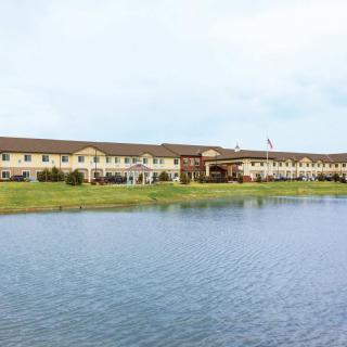 A hotel building situated by a lake under a clear sky.