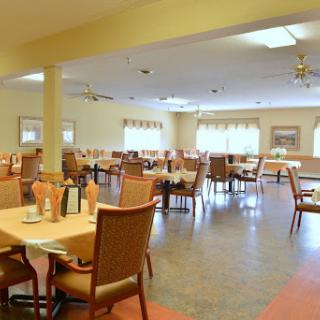 A spacious and inviting dining area featuring neatly arranged tables and chairs, perfect for casual meals.