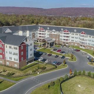 Aerial view of a large residential complex with landscaping and parking facilities.