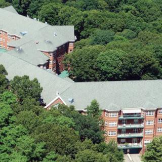 An aerial view of a large building surrounded by dense trees.
