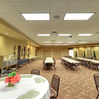 A well-lit conference room set up with tables and chairs, ready for a meeting or event.