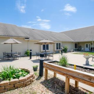 A sunny courtyard with outdoor seating and garden beds in a landscaped area.