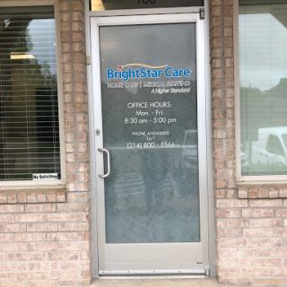 Entrance of a business office with clear glass door and signage.
