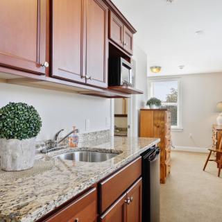 A modern kitchen with granite countertops and wooden cabinets.