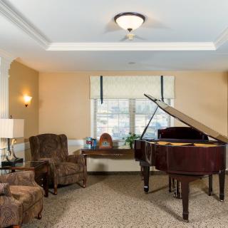 A cozy living room featuring a grand piano and comfortable seating.