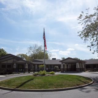 A view of a building with an American flag in front, set against a clear sky.