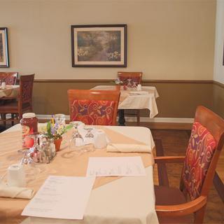 A cozy restaurant dining area with neatly set tables and colorful chairs.