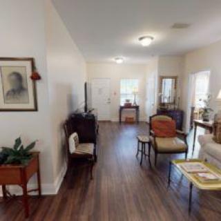 A cozy living room with hardwood floors, elegant furniture, and decorative artwork.