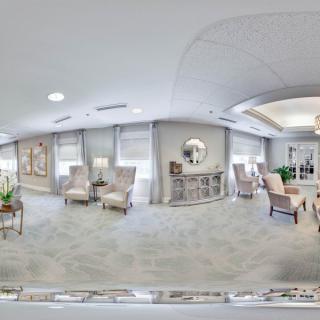 A spacious and elegantly decorated living room featuring comfortable seating, decorative items, and natural lighting.