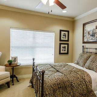 A cozy bedroom with a patterned bedspread and elegant decor.