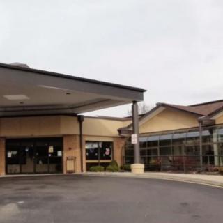 A commercial building with a covered entrance and driveway.