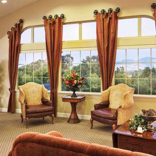 A cozy living room with elegant chairs and large windows offering a scenic view.
