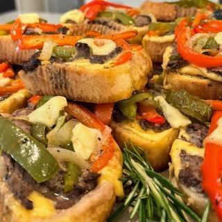 A delicious assortment of savory appetizers featuring bread topped with colorful bell peppers and vegetables.
