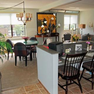 An open-plan living and dining area featuring elegant furniture, a chandelier, and stylish decor.