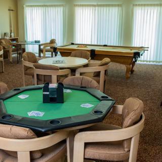 A recreational game room featuring a poker table and pool table with comfortable seating.