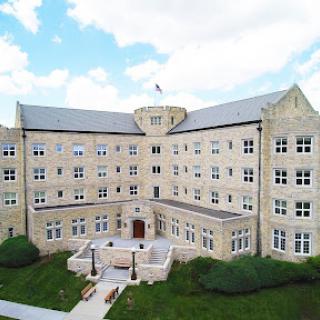A historical educational building showcasing stone architecture under a clear blue sky.