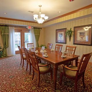 Elegant dining room with a wooden table and chairs, adorned with a chandelier and decorative artwork.