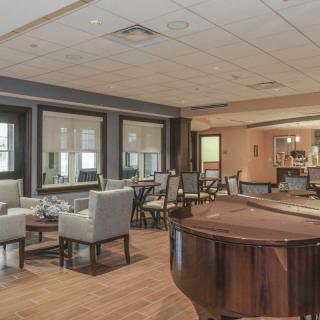 A spacious lounge area featuring a grand piano and comfortable seating.