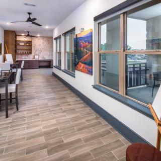 A modern open-concept kitchen and dining area with wood flooring, large windows, and colorful artwork.