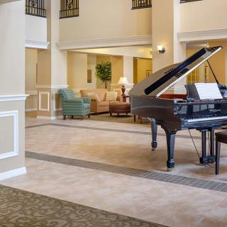 A spacious lobby with a grand piano and comfortable seating area.
