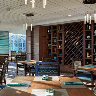 A modern restaurant interior featuring wood accents and a stylish wine rack.