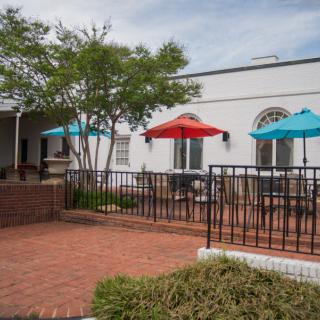 Outdoor patio area with colorful umbrellas and brick flooring.