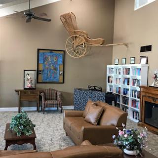 A cozy living room featuring a unique decor, including a bookshelf and an artistic piece suspended from the ceiling.