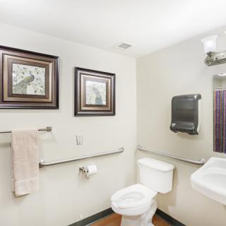 A clean, well-lit bathroom with framed artwork and modern fixtures.