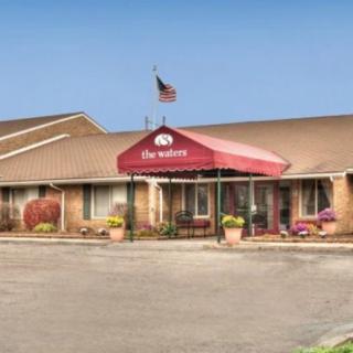 An exterior view of a hotel entrance with an awning and flag.