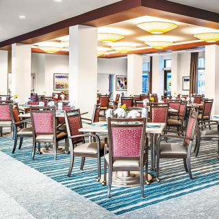 A modern dining area with neatly arranged tables and chairs, featuring elegant interior design.