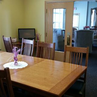 A cozy dining room featuring a wooden table set with chairs and a decorative centerpiece.