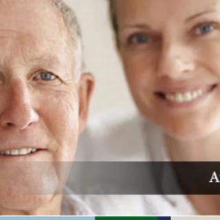 An elderly man and a woman smiling in a close-up portrait.