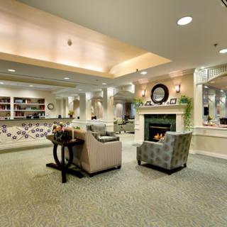A cozy and elegantly designed lobby featuring a seating area with armchairs and a fireplace.