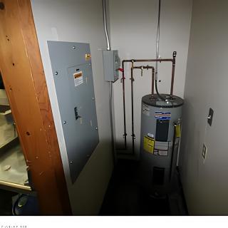 A utility room containing a water heater and an electrical panel.