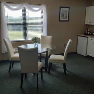 Bright dining area with a round table and four chairs near a window.