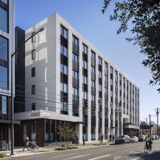 A modern residential building on a busy urban street.