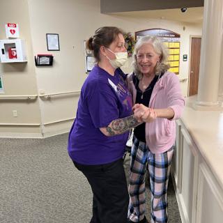 A joyful moment shared between a nurse and a patient in a hospital setting.