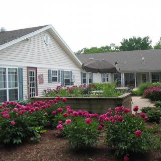 A charming house with a well-maintained garden full of blooming flowers and greenery.