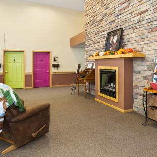 A cozy living room with a stone fireplace and colorful doors.