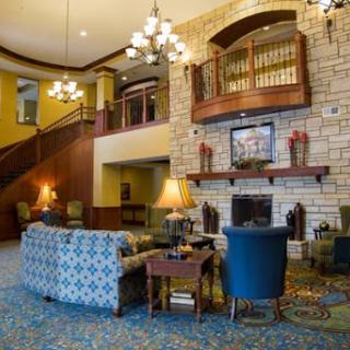 A cozy and inviting hotel lobby featuring comfortable seating, a fireplace, and decorative lighting.