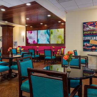 A modern dining area featuring colorful artwork and vibrant seating.