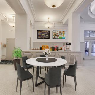 A modern dining area with a round table surrounded by chairs in a brightly lit room.
