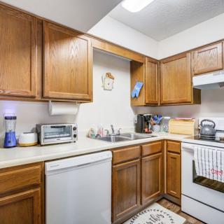 A cozy kitchen with wooden cabinets and various appliances.