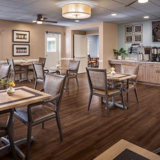 A well-lit dining area with wooden tables and chairs, featuring elegant interior decor.