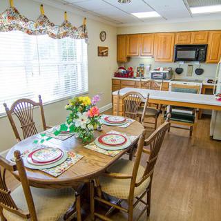 A cozy dining area with a set table and adjoining kitchen.
