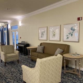 A cozy lounge area featuring a couch and chairs with framed artwork on the walls.