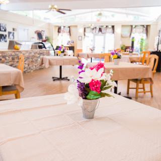 A tranquil dining area featuring neatly arranged tables and decorative flowers, perfect for a pleasant meal.