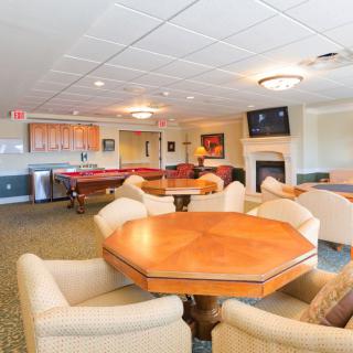 A cozy lounge area featuring a pool table, comfortable seating, and a fireplace.